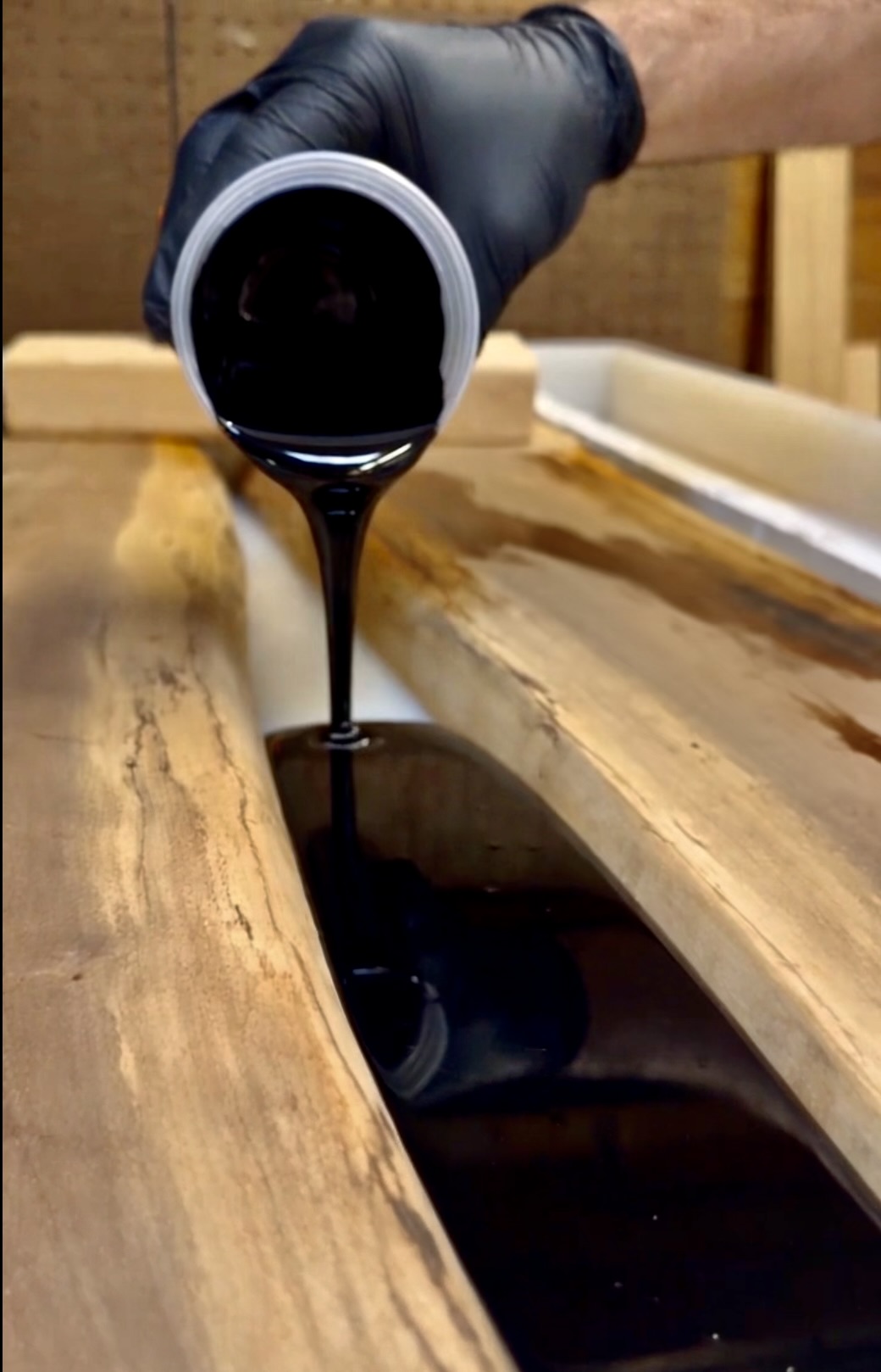 Pouring epoxy into the gap between two black walnut slabs