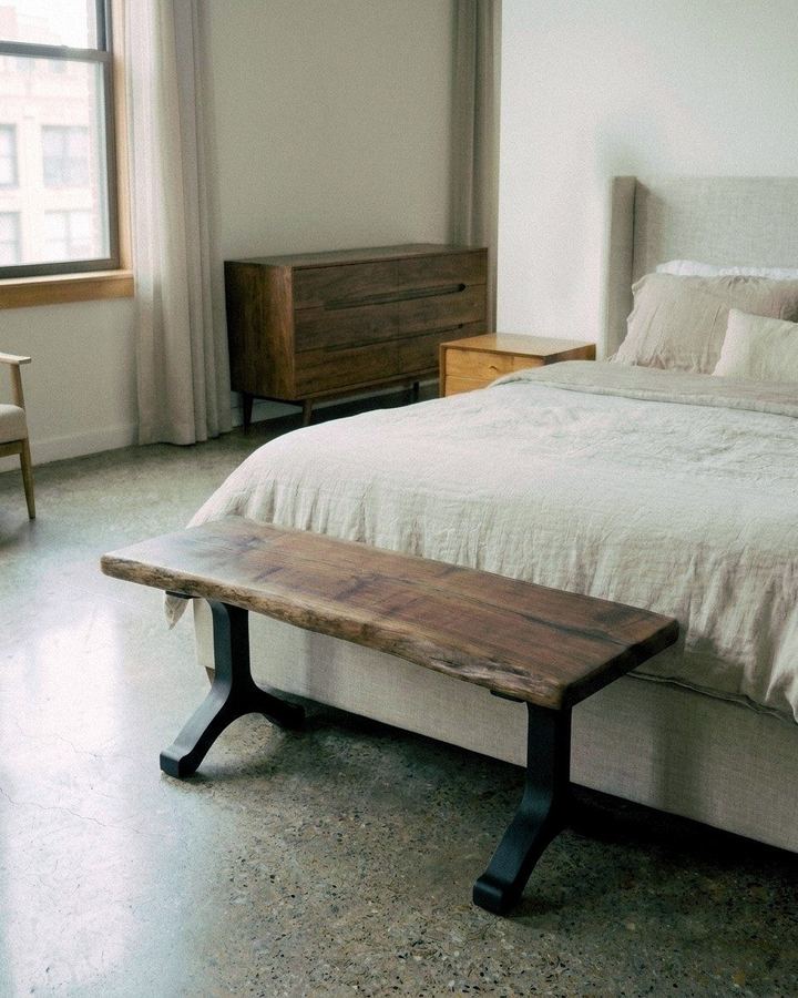 The Jamestown Bench with its Wishbone steel base at the foot of a bed in a bright bedroom